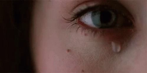 A Close Up Of A Woman 'S Eye With A Tear On It . GIF