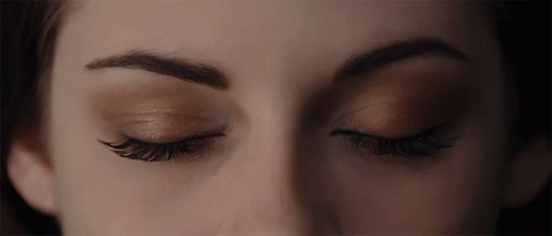 A Close Up Of A Woman 'S Eyes With A Dark Background GIF