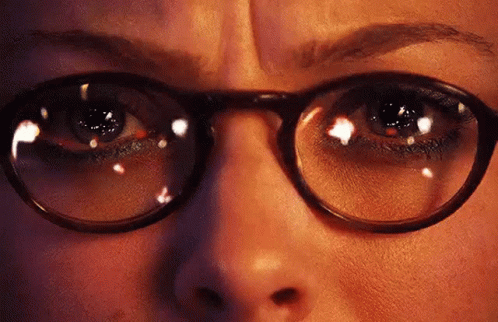 A Close Up Of A Woman 'S Eyes With Glasses On . GIF