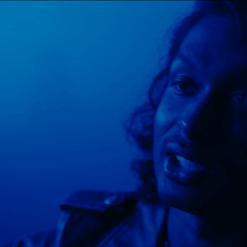 A Close Up Of A Woman 'S Face Against A Blue Background GIF