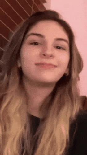 A Close Up Of A Woman 'S Face Against A Pink Background GIF