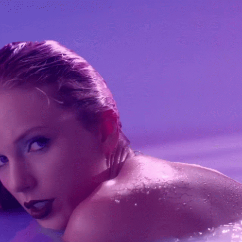 A Close Up Of A Woman 'S Face And Shoulder With Purple Background GIF