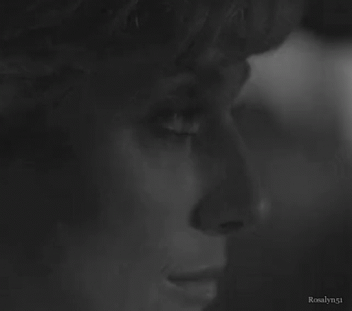 A Close Up Of A Woman 'S Face In A Black And White Photo GIF