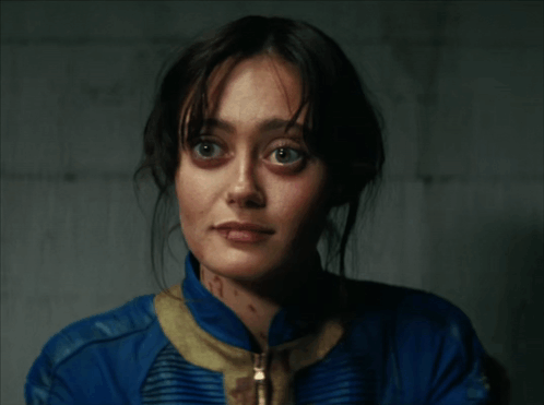 A Close Up Of A Woman 'S Face In A Blue Jacket GIF