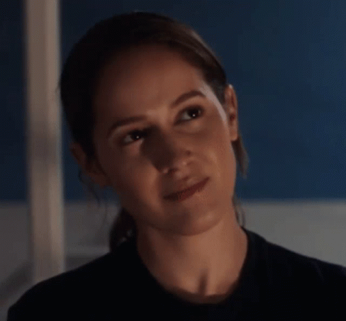 A Close Up Of A Woman 'S Face In A Dark Room . GIF