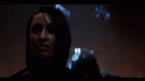 A Close Up Of A Woman 'S Face In A Dark Room With A Blurred Background GIF
