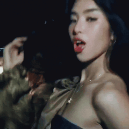 A Close Up Of A Woman 'S Face In A Dark Room With Her Mouth Open GIF