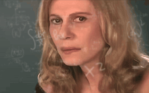 A Close Up Of A Woman 'S Face In Front Of A Blackboard With Math Equations GIF