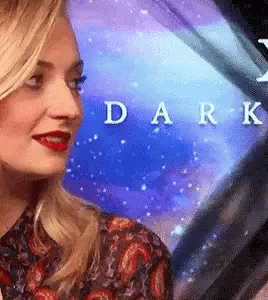 A Close Up Of A Woman 'S Face In Front Of A Blue Background With The Word Dark Written On It . GIF