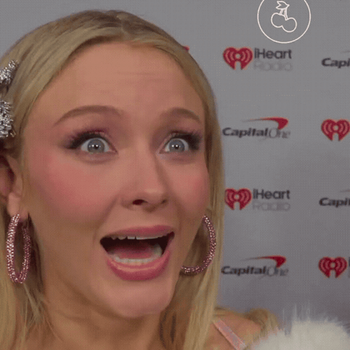 A Close Up Of A Woman 'S Face In Front Of A Capital One Logo GIF