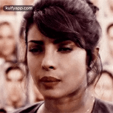 A Close Up Of A Woman 'S Face In Front Of A Crowd . GIF
