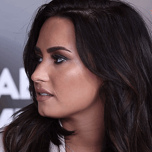 A Close Up Of A Woman 'S Face In Front Of A Sign That Says All GIF