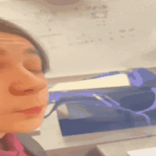 A Close Up Of A Woman 'S Face In Front Of A White Board With Numbers On It GIF