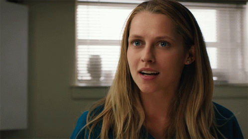 A Close Up Of A Woman 'S Face In Front Of A Window With Blinds GIF