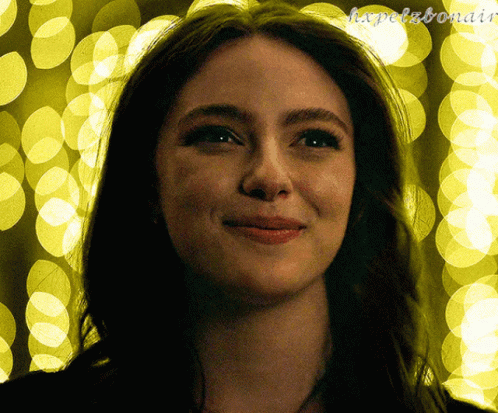 A Close Up Of A Woman 'S Face In Front Of A Yellow Background With The Letters H.x.pelzbonair GIF