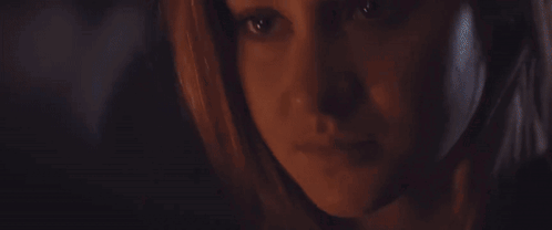 A Close Up Of A Woman 'S Face In The Dark GIF