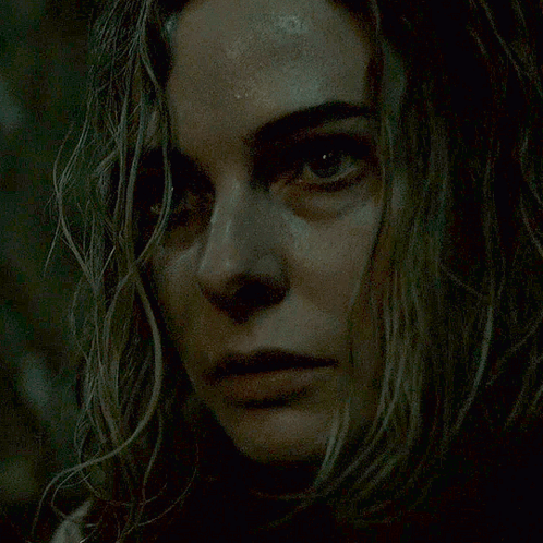 A Close Up Of A Woman 'S Face In The Dark GIF