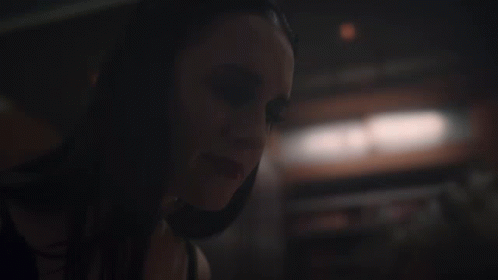 A Close Up Of A Woman 'S Face In The Dark GIF