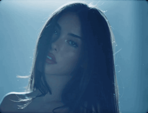 A Close Up Of A Woman 'S Face In The Dark GIF