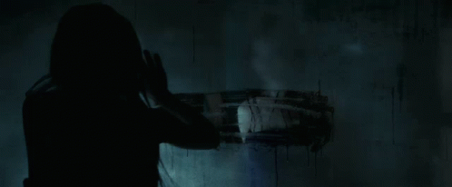 A Close Up Of A Woman 'S Face In The Dark With Her Mouth Open GIF