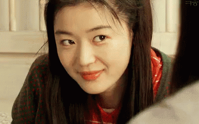 A Close Up Of A Woman 'S Face Looking At The Camera . GIF