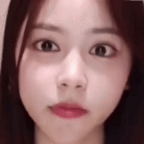 A Close Up Of A Woman 'S Face Making A Funny Face With Her Eyes Closed . GIF