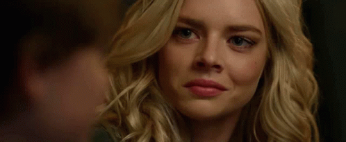 A Close Up Of A Woman 'S Face Smiling With A Man Behind Her . GIF