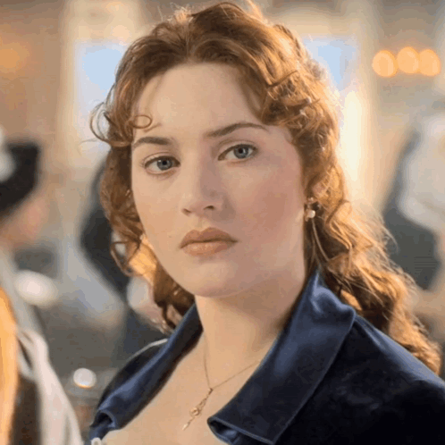 A Close Up Of A Woman 'S Face Wearing A Blue Shirt GIF