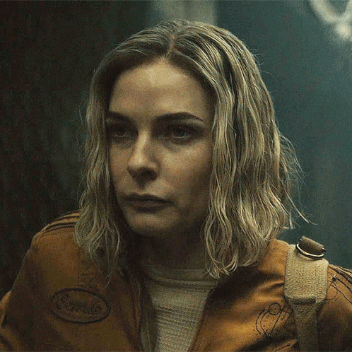 A Close Up Of A Woman 'S Face Wearing A Brown Jacket GIF