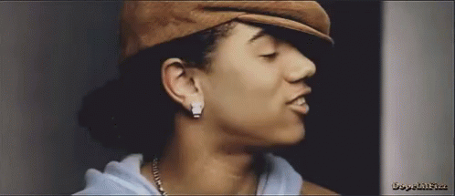 a close up of a woman 's face wearing a hat and earrings