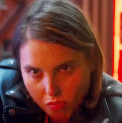 A Close Up Of A Woman 'S Face Wearing A Leather Jacket . GIF