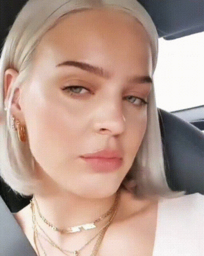 A Close Up Of A Woman 'S Face Wearing A Necklace GIF