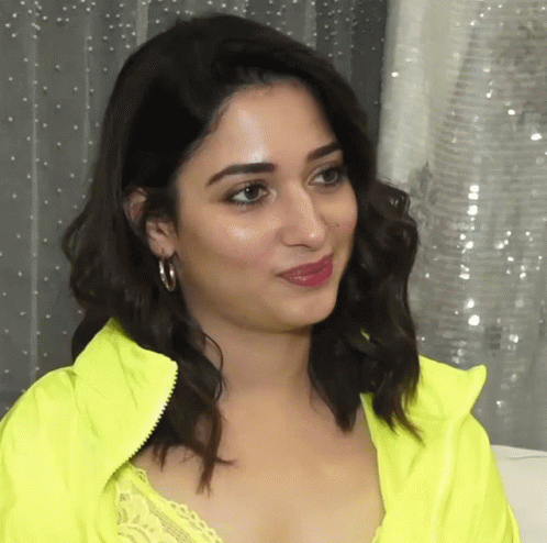 A Close Up Of A Woman 'S Face Wearing A Neon Yellow Jacket GIF