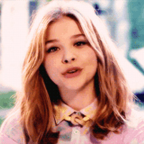 A Close Up Of A Woman 'S Face Wearing A Pink Shirt And A Yellow Bow Tie . GIF