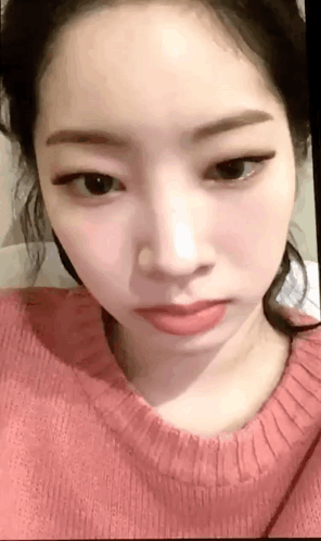 A Close Up Of A Woman 'S Face Wearing A Pink Sweater And Red Lipstick . GIF