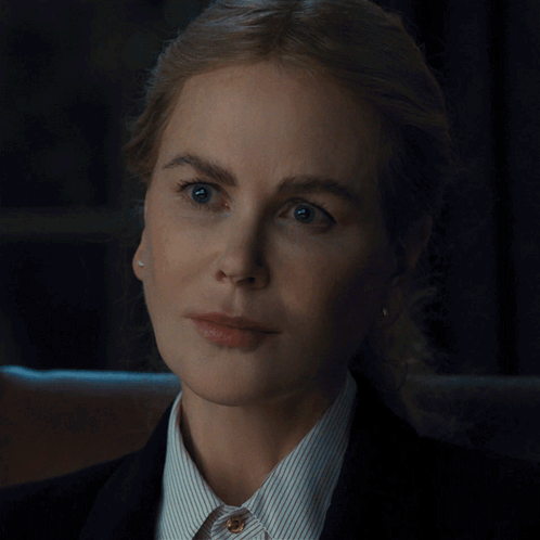 A Close Up Of A Woman 'S Face Wearing A Striped Shirt And A Black Jacket GIF