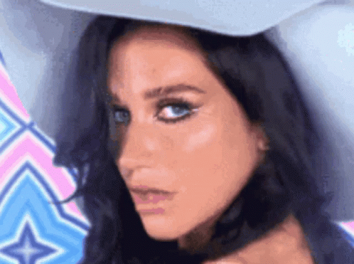 A Close Up Of A Woman 'S Face Wearing A White Hat GIF
