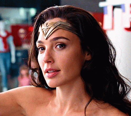 A Close Up Of A Woman 'S Face Wearing A Wonder Woman Headband GIF