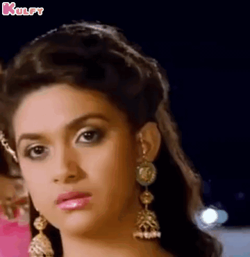 A Close Up Of A Woman 'S Face Wearing Earrings And A Crown . GIF