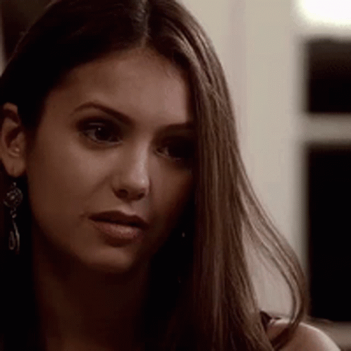 A Close Up Of A Woman 'S Face Wearing Earrings . GIF