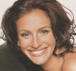 A Close Up Of A Woman 'S Face With A Big Smile GIF