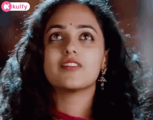 A Close Up Of A Woman 'S Face With A Bindi On Her Forehead Looking Up . GIF