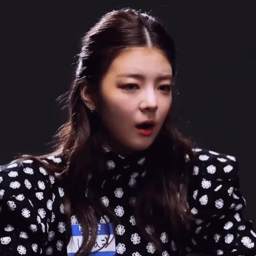 A Close Up Of A Woman 'S Face With A Black And White Polka Dot Dress GIF