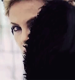 A Close Up Of A Woman 'S Face With A Black Fur Coat Covering Half Of Her Face . GIF