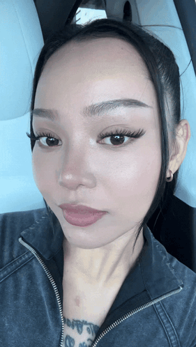 A Close Up Of A Woman 'S Face With A Black Jacket On GIF