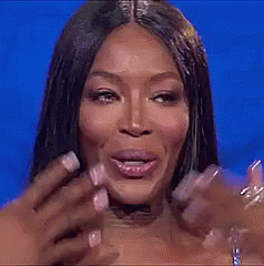 A Close Up Of A Woman 'S Face With A Blue Background And Her Hand On Her Face . GIF