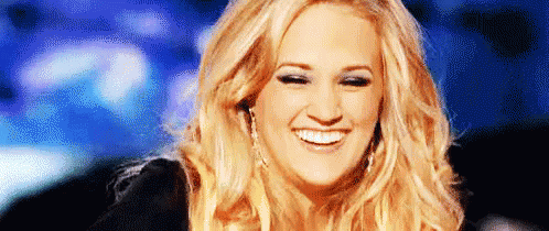 A Close Up Of A Woman 'S Face With A Blue Background . GIF