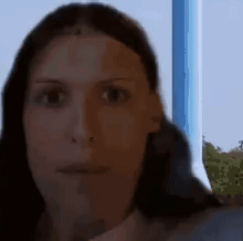 A Close Up Of A Woman 'S Face With A Blue Background GIF