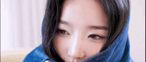 A Close Up Of A Woman 'S Face With A Blue Blanket Covering Her Face . GIF