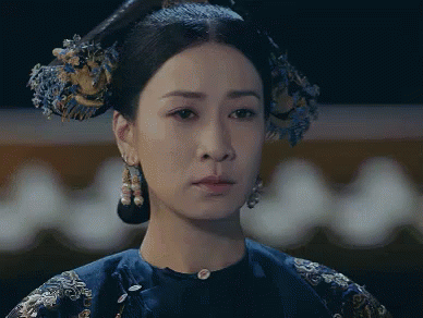 A Close Up Of A Woman 'S Face With A Blue Dress On GIF